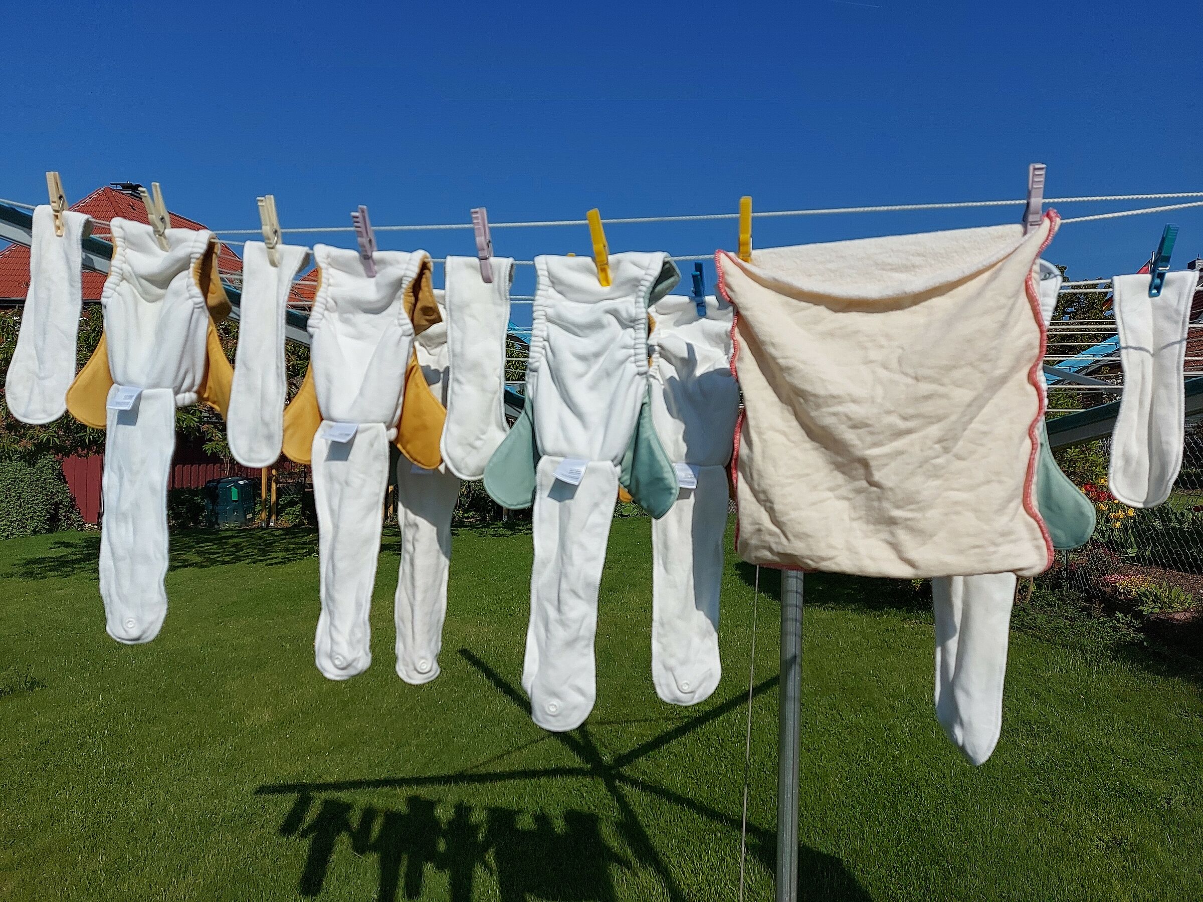 Stoffwindel vs. Einwegwindel: Auf einer Leine im Garten hängen Stoffwindelhosen zum Trocknen. (Foto: Susann Köthe/stock.adobe.com)