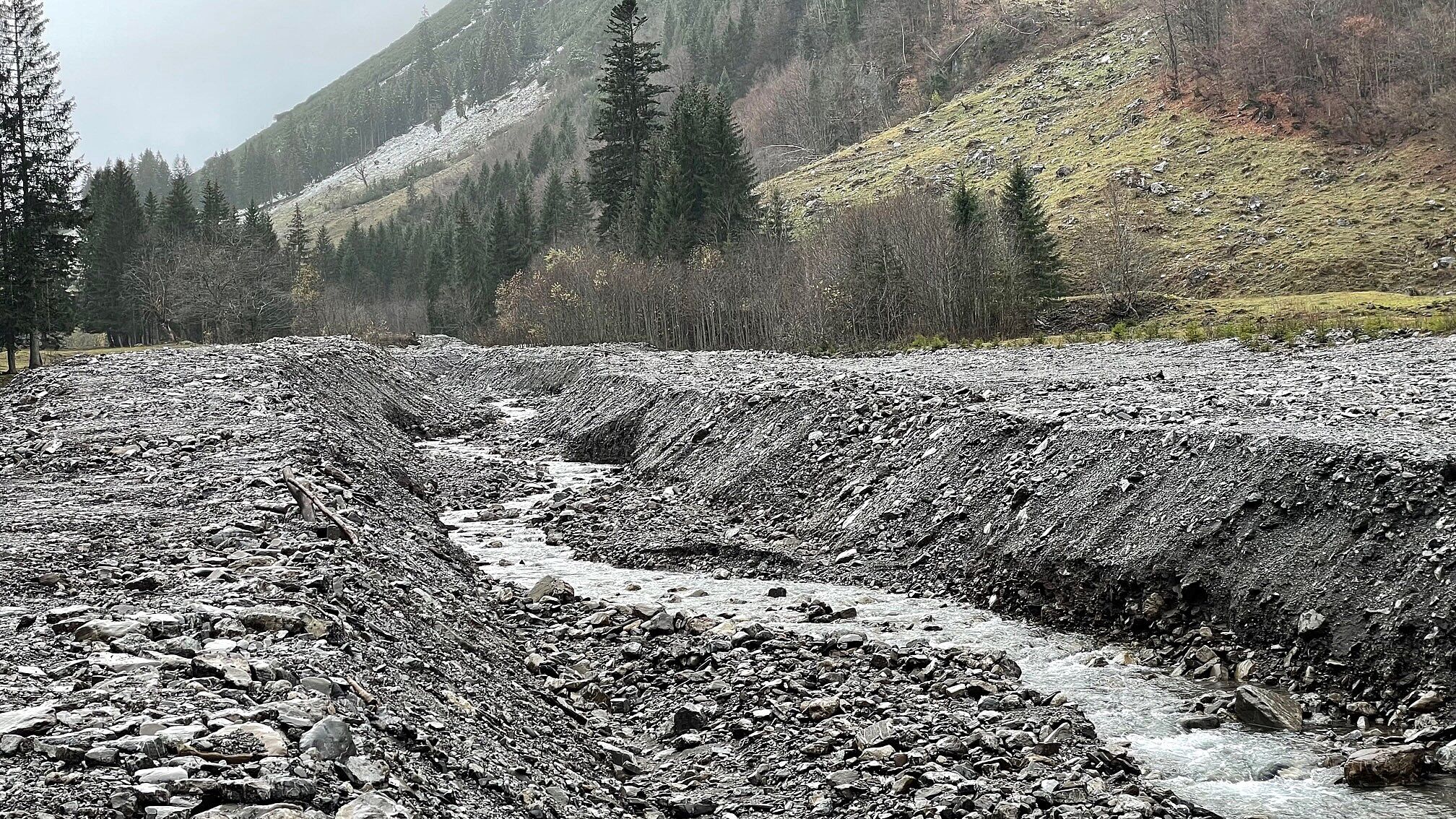 Die ursprüngliche Lebenswelt des Wildflusses und der Uferzonen ist auf Jahrzehnte geschädigt (Foto: Udo Schmitz). Der zerstörte Rappenalpbach fließt durch einen Kanal aus aufgeschüttetem Kies.