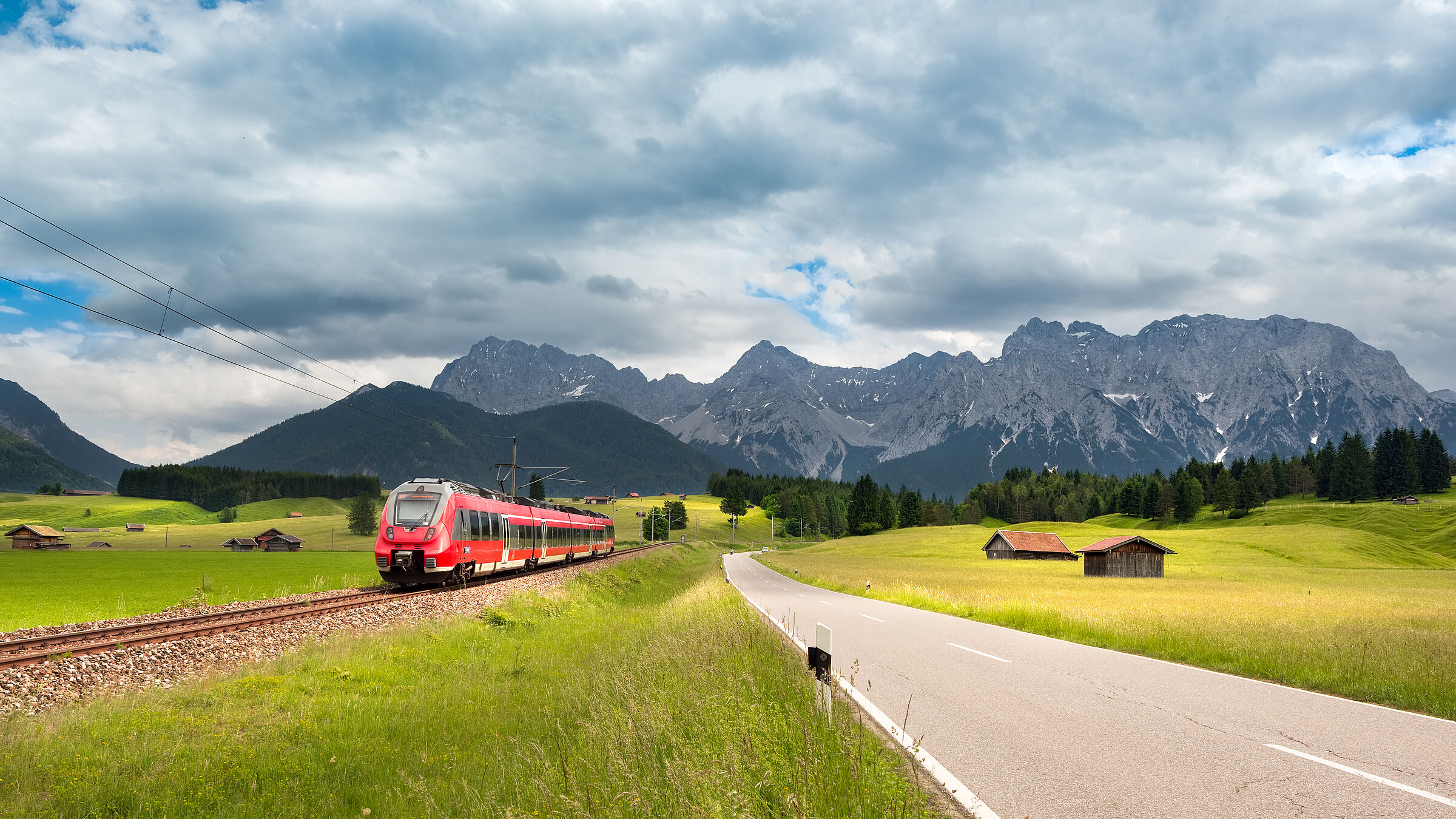 Ein Personenzug bei Mittenwald vor der Bergkulisse des Karwendelgebirges.