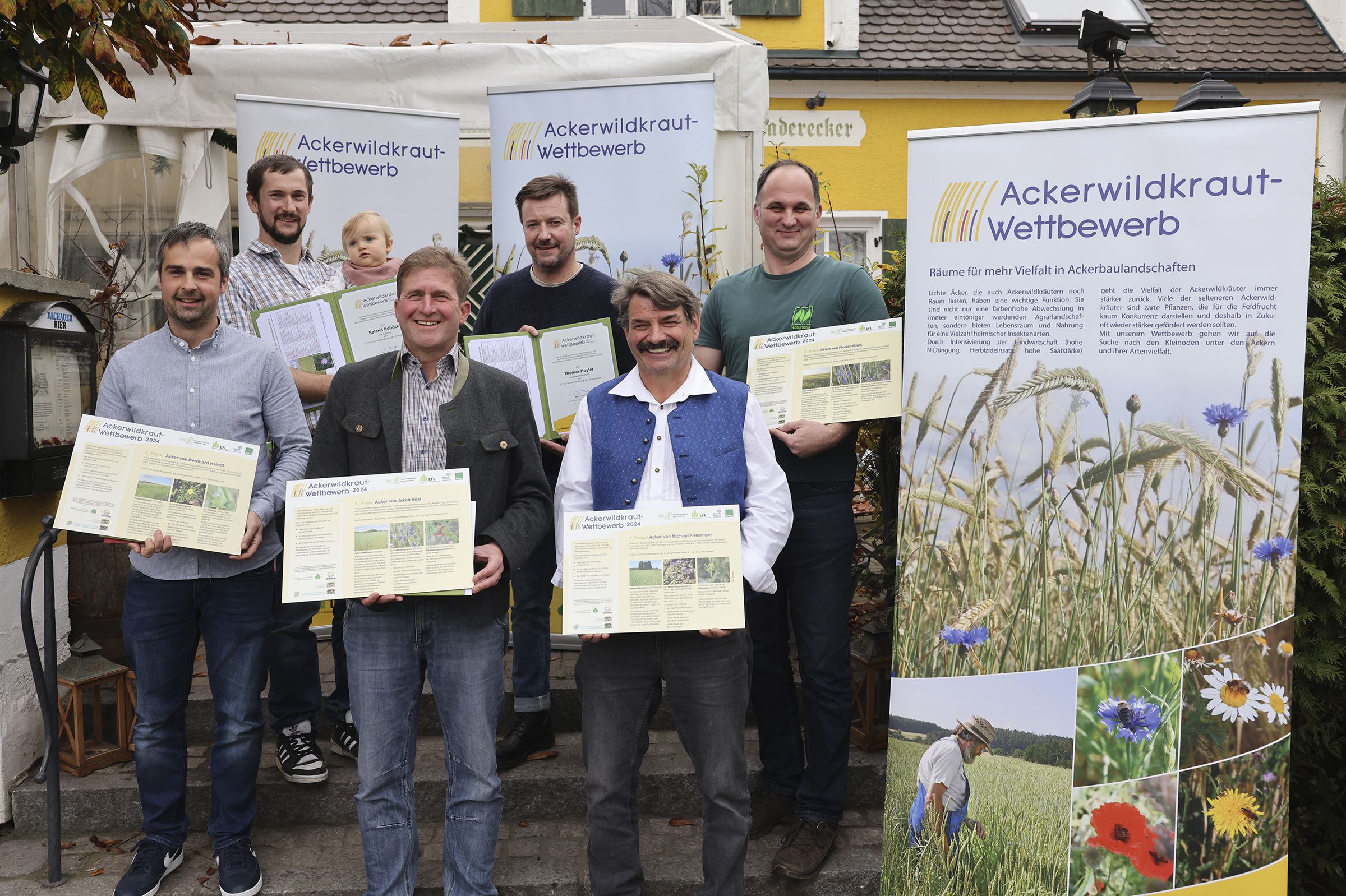 Die Preisträger des Ackerwildkraut-Wettbewerbs 2024: (v.li.) Bernhard Heindl (2. Preis), Roland Koböck (3. Preis), Jakob Bösl (1. Preis), Thomas Hoyler (3. Preis), Michael Friedinger (1. Preis), Florian Gäck (2. Preis) (Foto: Birgit Gleixner, LfL) Die Preisträger des Ackerwildkrautwettbewerbes 2024 vor Plakaten zum Ackerwildkraut-Wettbewerb (Foto: Birgit Gleixner, LfL)