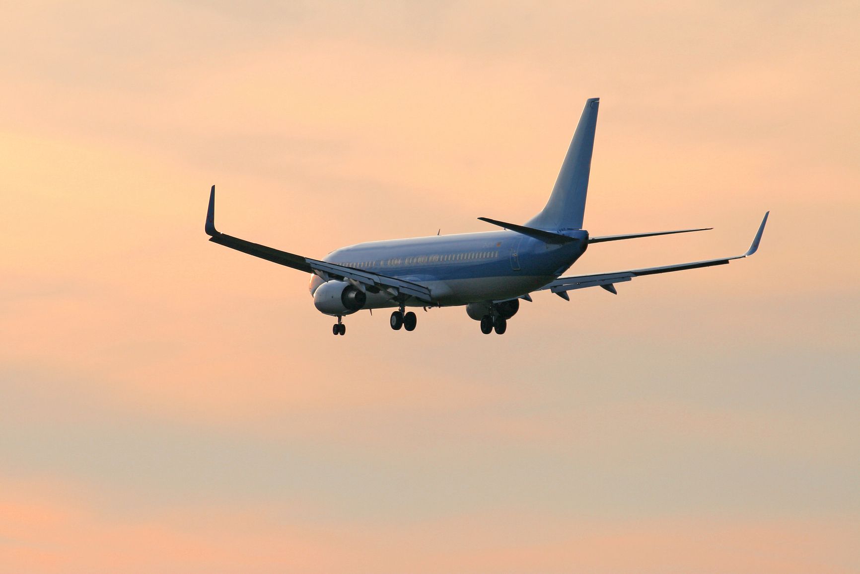 Flugzeug im Landeanflug vor rotem Himmel: Der angebliche Bedarf für die dritte Startbahn München wird mit einer unrealistischen Zunahme an Flugbewegungen begründet. (Foto: Rebmann/clipdealer.de)