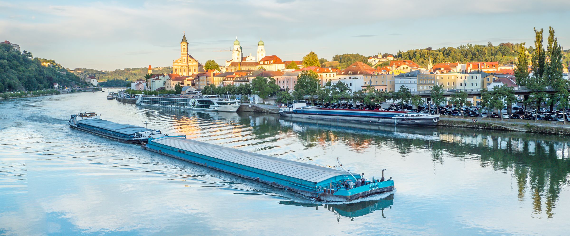 Ein großes Lastschiff passiert die Stadt Passau auf der Donau: Schifffahrt in Bayern kann zum ökologischen Verkehr beitragen, insbesondere der gute Zustand der Gewässer muss aber im Vordergrund stehen. (Bild: AdobeStock/Animaflora PicsStock)