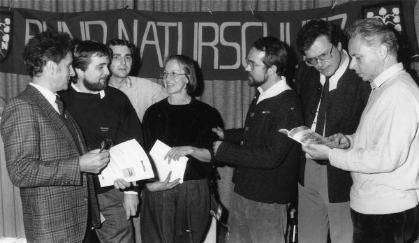 Grünes Band, Erstes Treffen 1990: Sieben Naturschützer aus Ost und West mit der ersten Resolution zum Grünen Band in der Hand stehen vor einem BUND-Naturschutz-Transparent