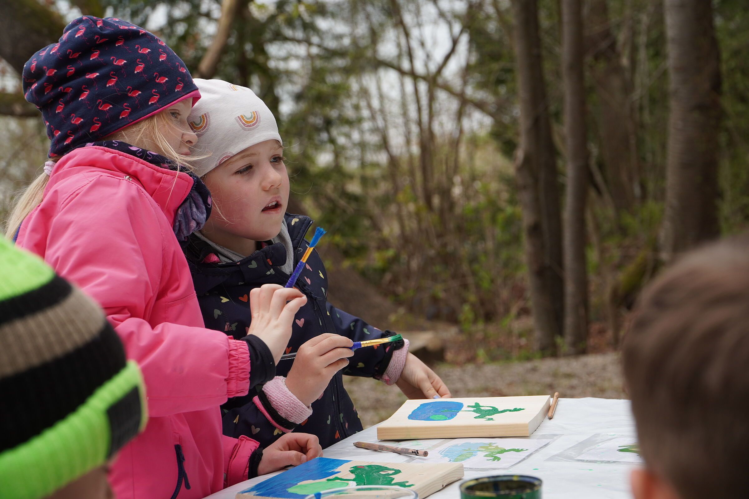 Kinder malen auf Holzbrettern (Bild: Rebekka Lochstampfer)