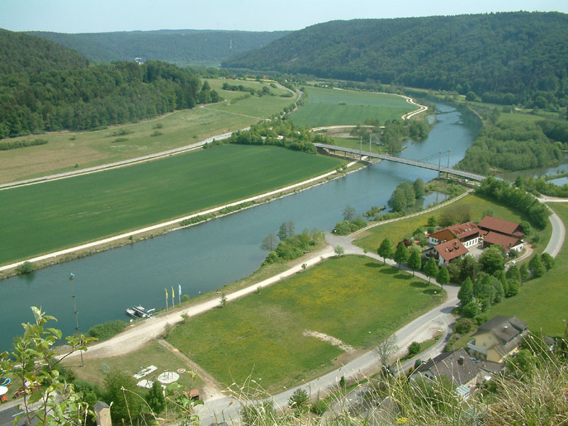 Blick auf den Fluss von oben, die Landschaft ist grün, das Ufer ist sehr gerade