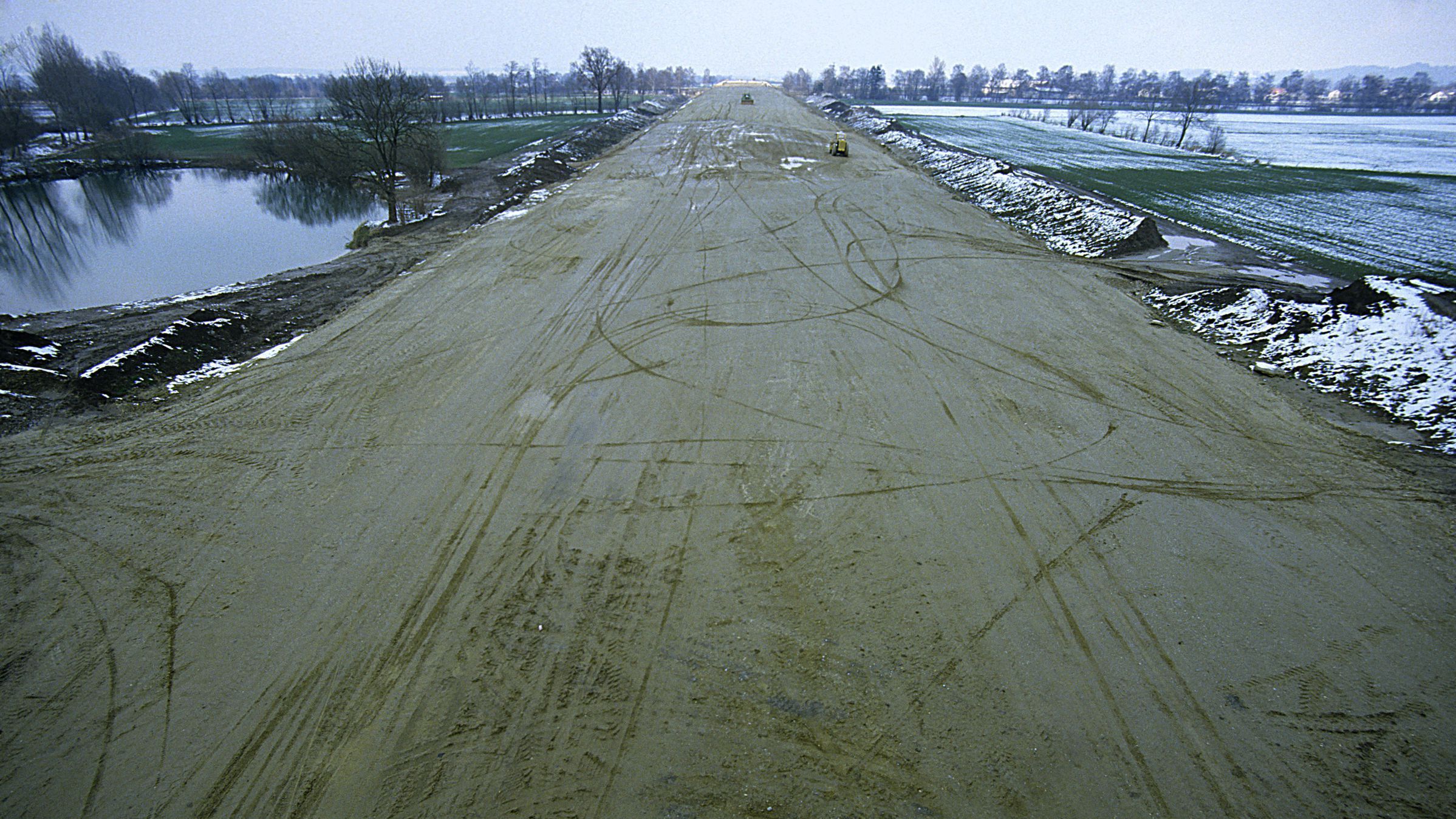 Landschaftszerschneidung durch Autobahnbau Erdinger Moos 1985. (Foto: Wolfgang Willner) Gefährdung von Amphibien: Autobahnbau durch das Erdinger Moos 1985, links ein Feuchtbiotop, in der Mitte die Straßentrasse – das Wandern zu noch vorhandenen Lebensräumen wird so zur Gefahr für Amphibien. (Foto: Wolfgang Willner)