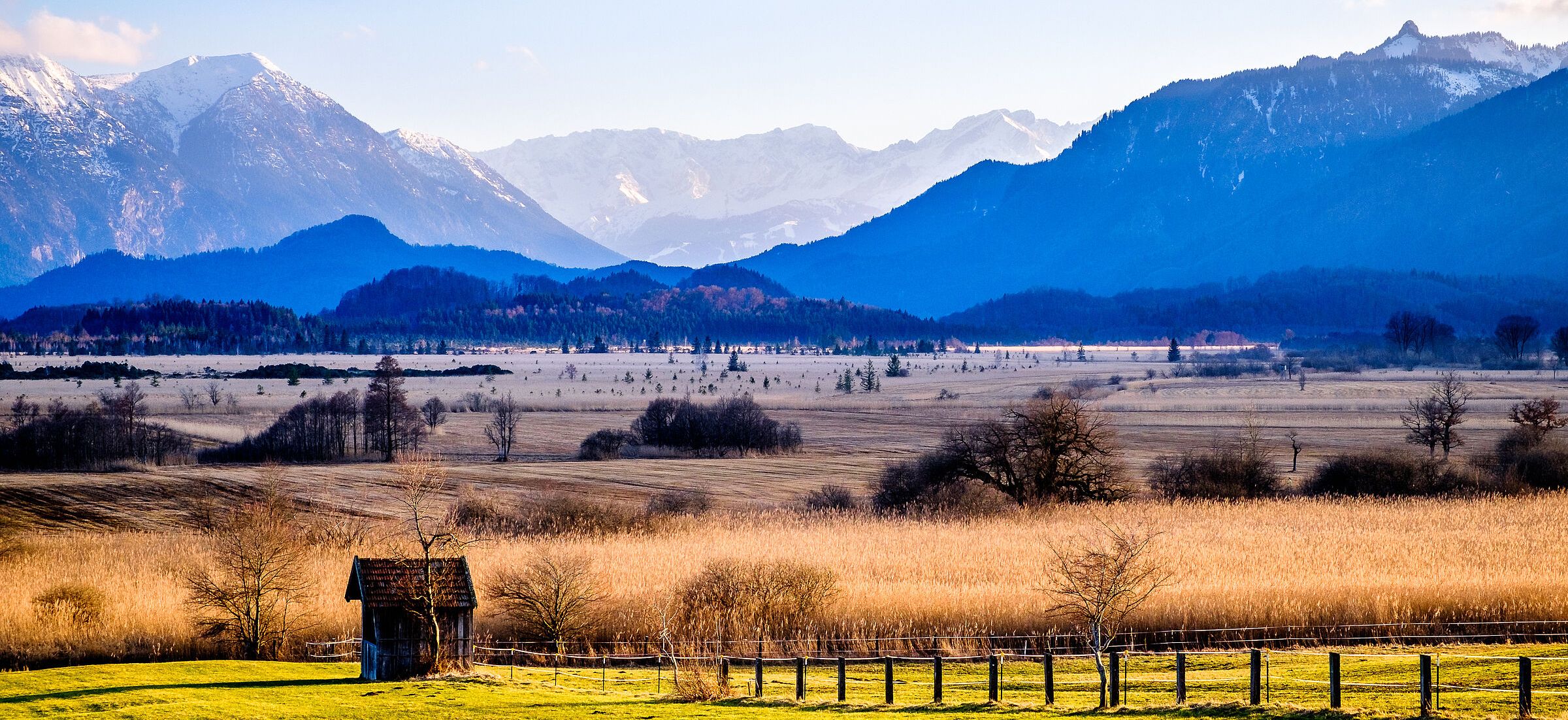 Gehört zu den bedeutendsten Moorkomplexen in Europa: das Murnauer Moos bei Garmisch-Partenkirchen (Foto: fottoo/stock.adobe.com). Eine Moorlandschaft vor verschneiten Bergen (Foto: fottoo/stock.adobe.com)