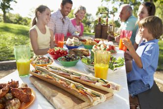 Mit Freunden oder der Familie feiern geht auch ökologisch. Beispielsweise draußen und ohne Wegwerfgeschirr (Foto: Monkey Business/fotolia.com) Eine Familie feiert bei Sonnenschein draußen im Garten. Ganz ohne Wegwerfgeschirr und mit gesundem Essen.