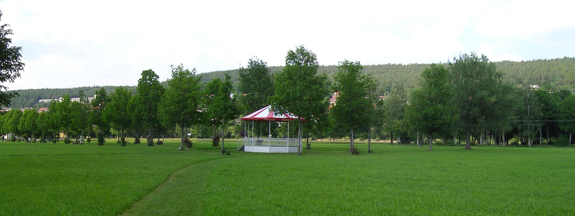 Pavillion im Kurgarten Bad Bocklet, eine grüne Wiese im Vordergrund und Bäume im Hintergrund