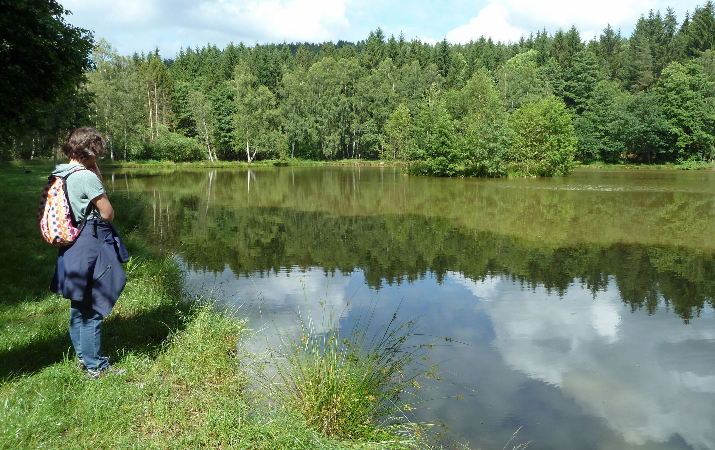 Ein Weiher im Püttlachtal, davor eine Wandererin. (Foto: Winfried Berner)