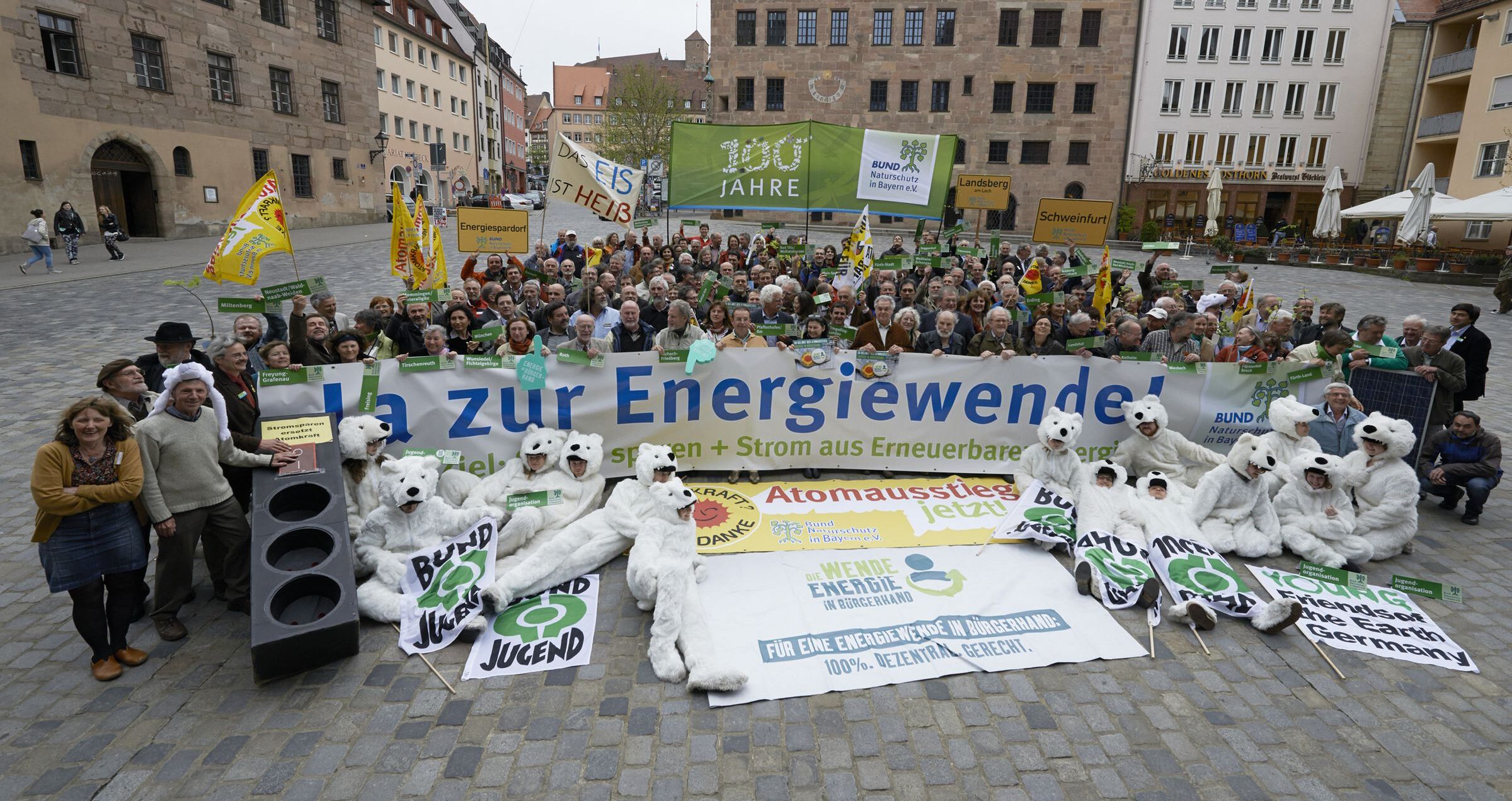 BN-Demonstration für die Energiewende: BN-Aktive halten auf einem Marktplatz Transparente, im Vordergrund haben es sich als Eisbären verkleidete Mitglieder der JBN-Jugendorganisation bequem gemacht. (Foto: Toni Mader)