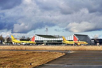 Urlaubsflieger vor dem Flughafen Memmingen (Bild: Sven Mayer) Zwei Urlaubsflieger vor dem Allgäu Airport Memmingen, im Hintergrund die Flughafenhalle. (Bild: Sven Mayer)