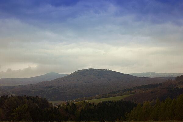 Die Rhön - das Land der offenen Fernen (Foto: Thorsten Grohse - stock.adobe.com) Unter einem wolkenverhangenen Himmel ziehen sich bewaldete Hügel dahin. (Foto: Thorsten Grohse/stock.adobe.com)