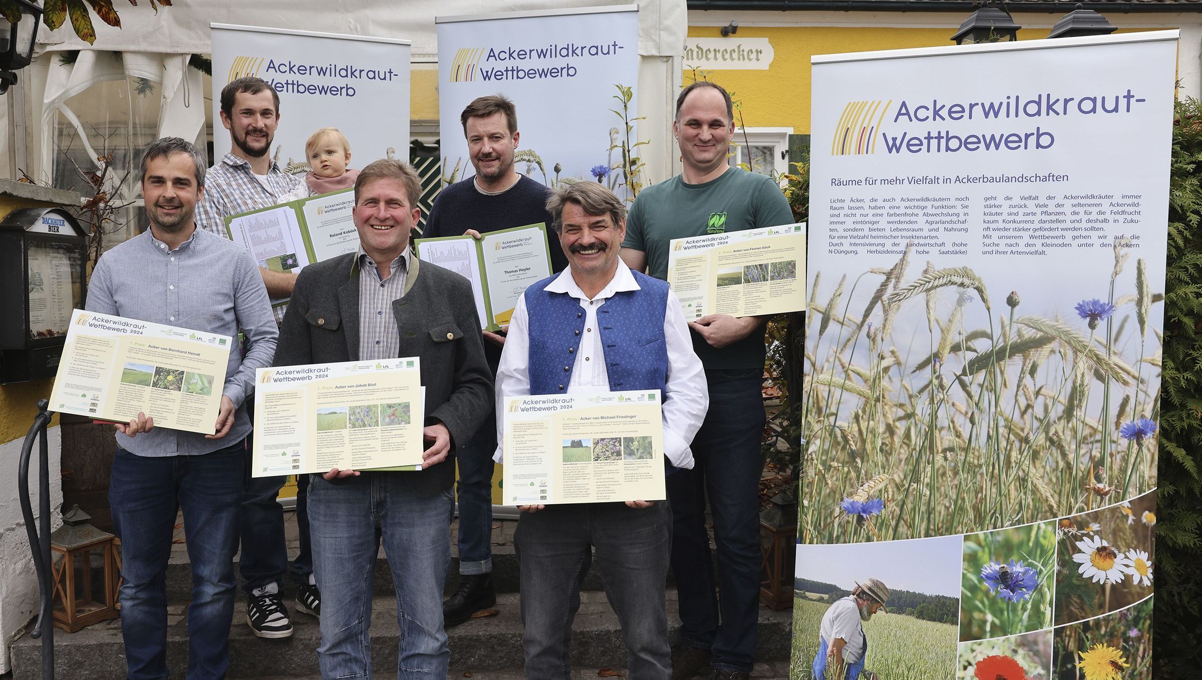 Die Preisträger des Ackerwildkrautwettbewerbes 2024 vor Plakaten zum Ackerwildkraut-Wettbewerb (Foto: Birgit Gleixner, LfL)