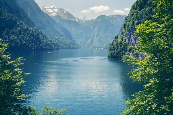 Der BN bewahrte den Königssee 1916/1917 vor einer monumentalen Verschandelung. 1921 wurde das gesamte Gebiet um den See auf Antrag des BN unter Schutz gestellt. Es bildete die Basis für den 1976 eingerichteten Nationalpark. (Foto: Serkat/fotolia.com) Blick auf einen tiefblauen See umgeben von steilen, bewaldeten Bergen. Im Hintergrund verschneite Gipfel. (Foto: Serkat/fotolia.com)