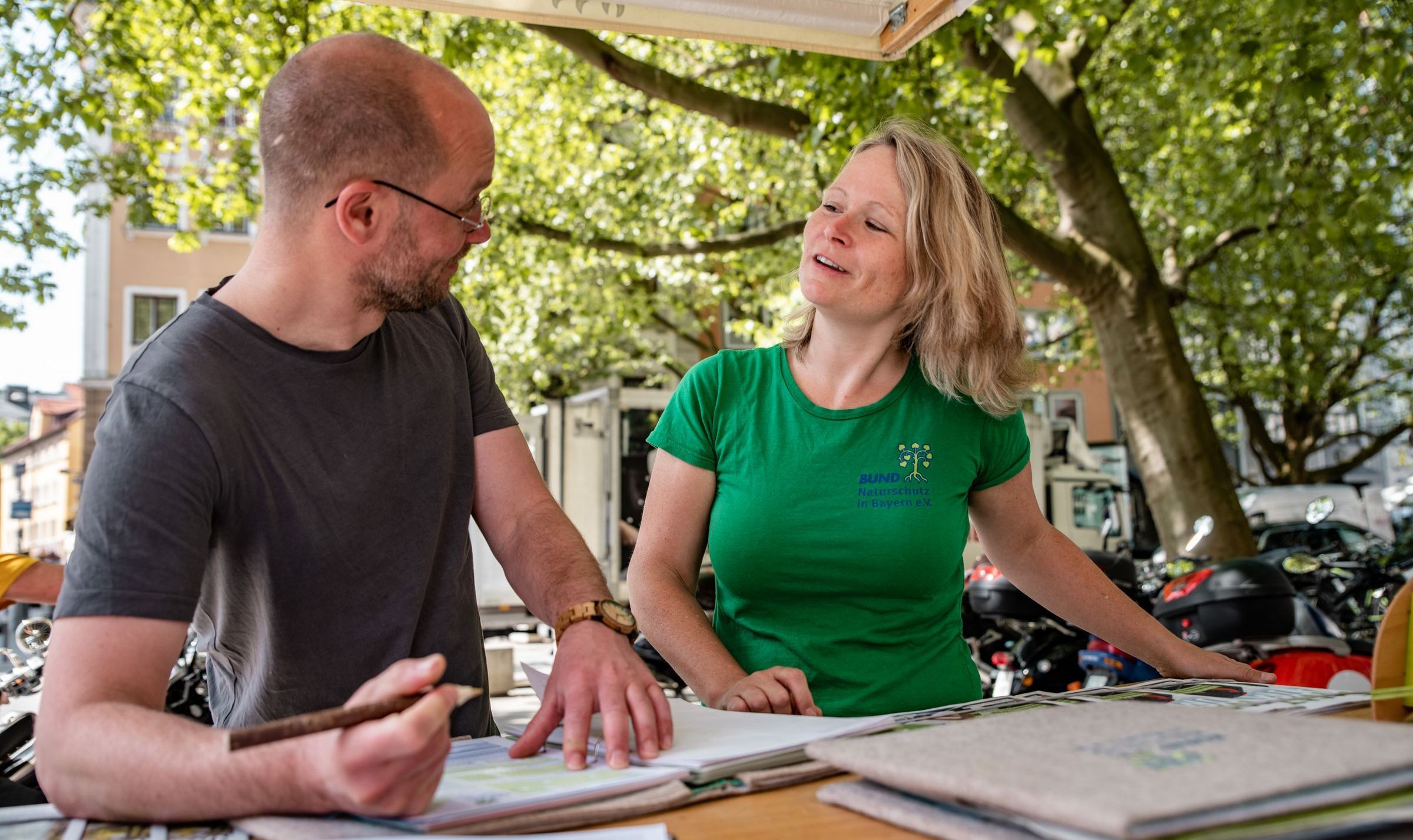 Foto: Thomas Vonier Fotografie Eine blonde Frau im BN Shirt redet begeistert mit einem Herrn, der gerade eine Liste unterschreibt