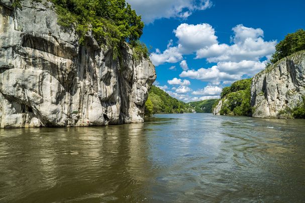 Am Donaudurchbruch: Ein breiter Fluss fließt durch bewaldete, steile Felswände. (Foto: Andy Ilmberger/stock.adobe.com)