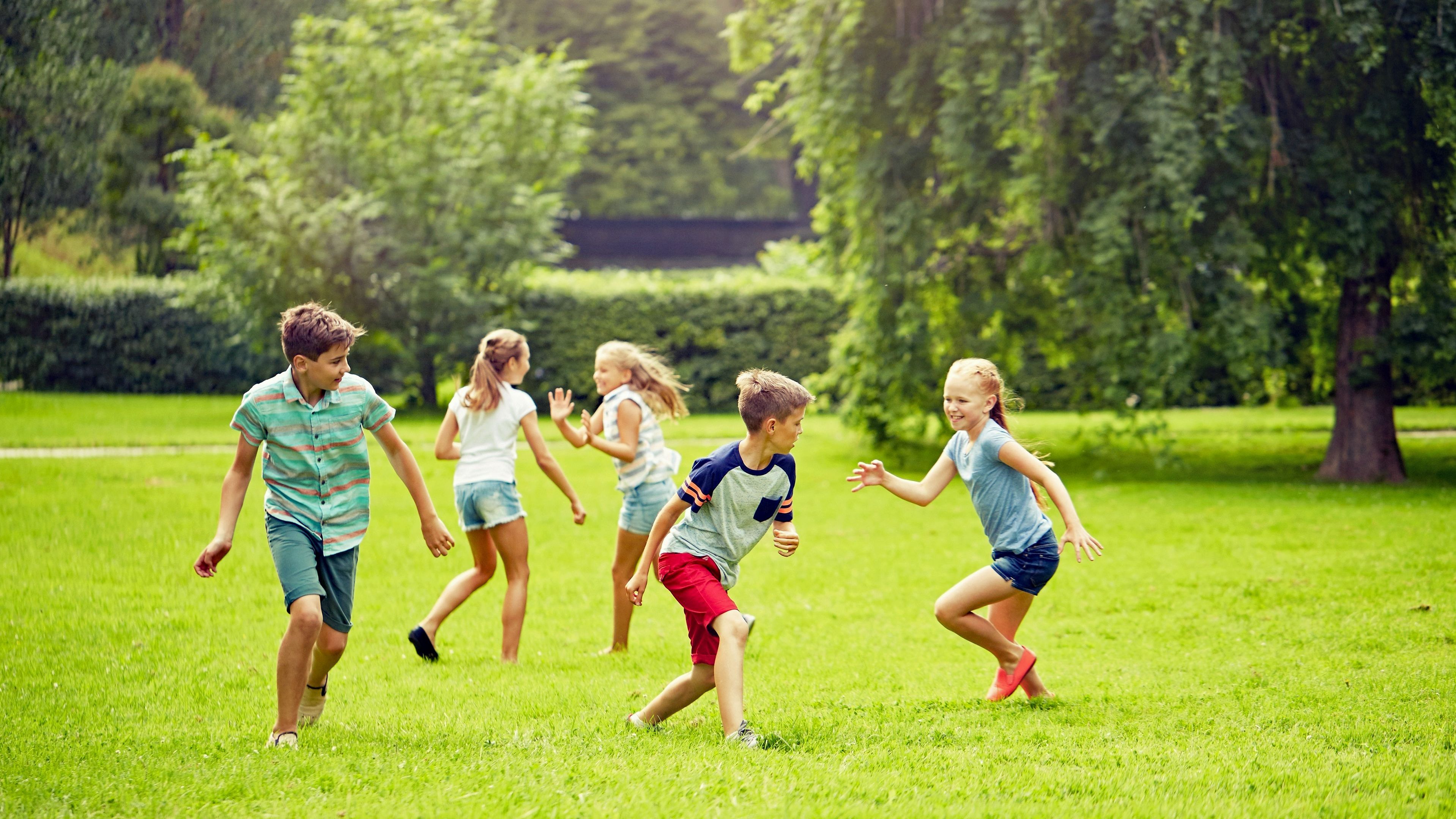 Spielen im Grünen stärkt Aufmerksamkeit und Selbstkontrolle. Gerade Kinder mit ADHS profitieren nachweislich vom Aufenthalt im Grünen (Foto: Syda Productions/stock.adobe.com). Stadtnatur und Gesundheit: Kinder laufen auf der Wiese eines Stadtparks umher und spielen.