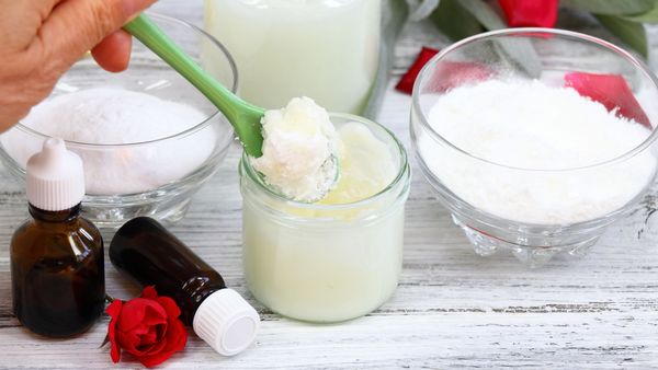 Deo selber machen: Auf einem Tisch stehen Glasschälchen mit Kokosöl oder Kakobutter, Natron, Stärke und ätherischem Öl für ein selbstgemachtes Deo.