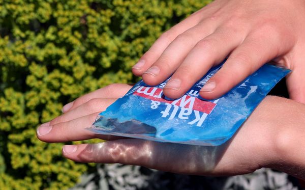 Erst Wärme, dann Kühle: So behandelt man einen Wespenstich am effektivsten. (Foto: Marina Lohrbach/stock.adobe.com) Jemand kühlt einen Wespenstich an seiner Hand mit einem Icepack