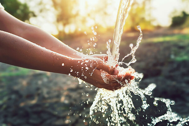 Ein Wasserstrahl fließt in ausgebreitete Hände: Wasser sparen hat viele Facetten. (Foto: lovelyday12/stock.adobe.com)