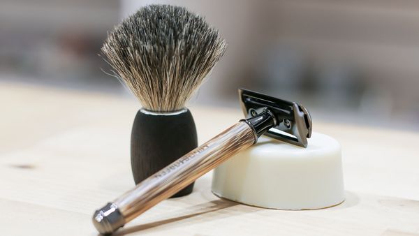 Nachhaltig rasieren: Rasierpinsel, Rasierhobel und Rasierseife liegen auf einem weißen Handtuch.