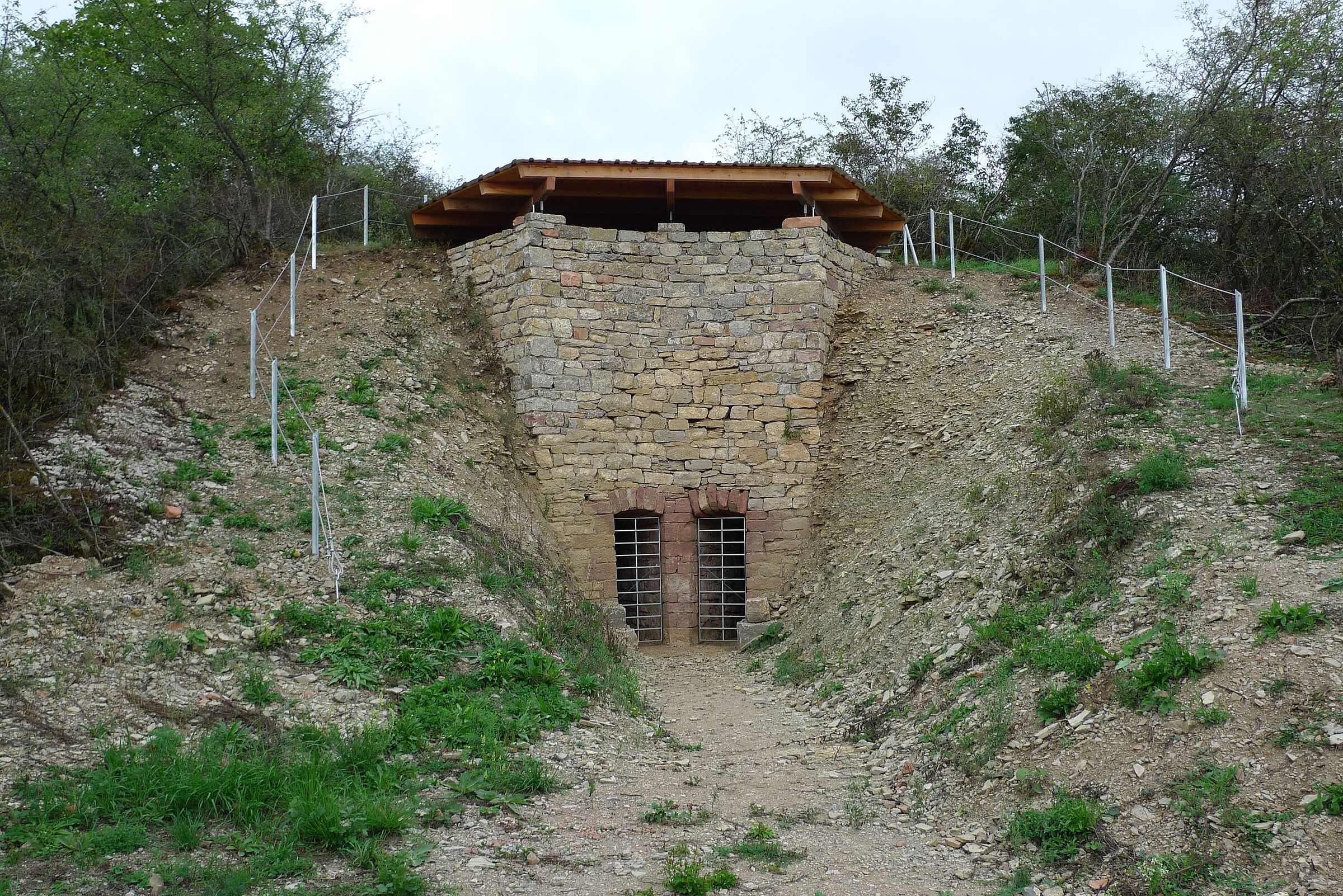Ein Bauwerk aus Steinquadern mit zwei Gittertüren