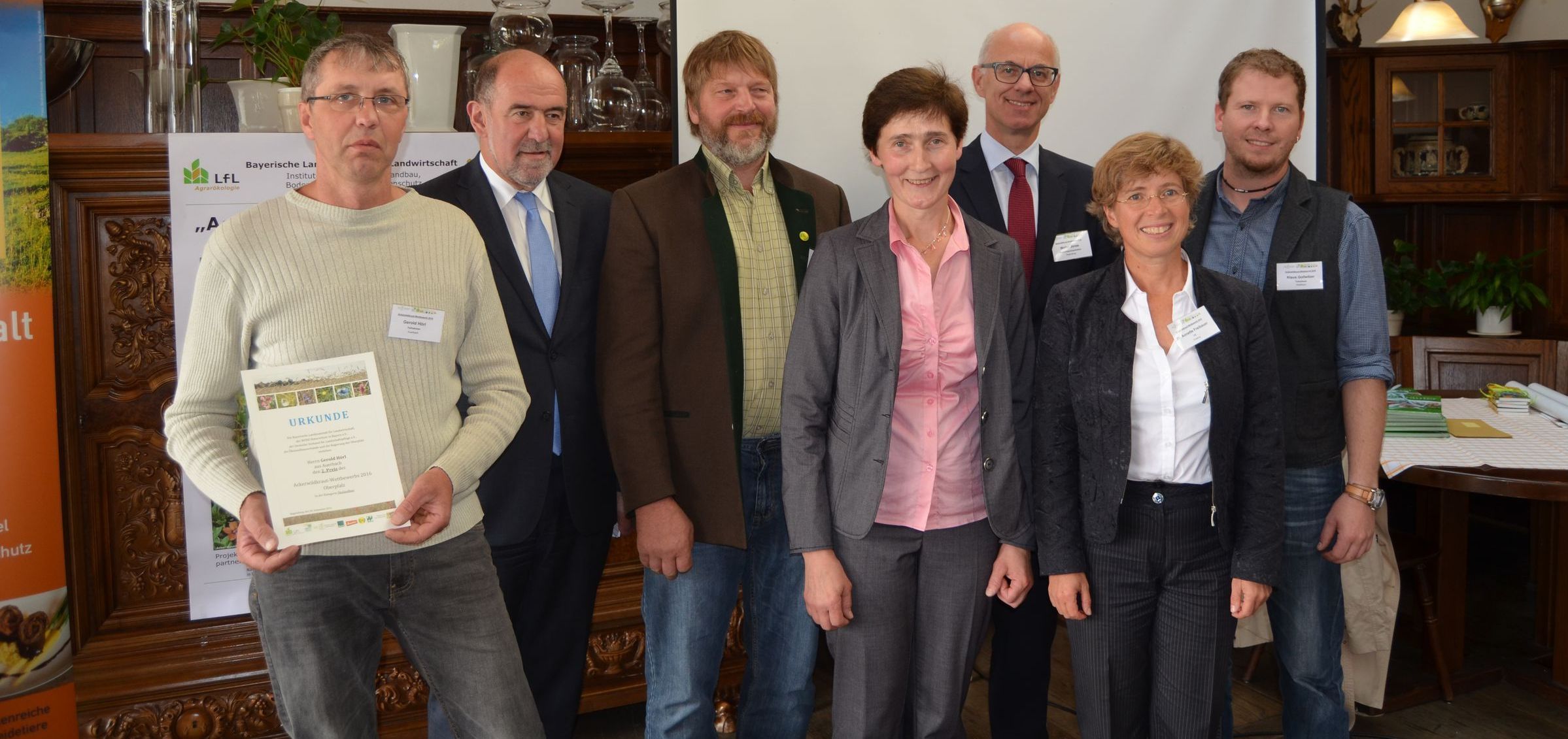 Eine Gruppe von sechs Leuten steht in einem Saal. Einer hält eine Urkunde in den Händen. Die Preisverleihung für den Ackerwildkraut-Wettbewerb 2016 fand im September in Regensburg statt. (Tim Fluhrer/BN)