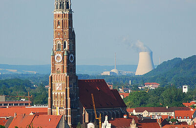 Das Atomkraftwerk liegt nahe der Stadt Landshut. Im Vordergrund ist der Kirchturm von St. Martin in Landshut, im Hintergrund das Atomkraftwerk zu sehen (Foto: Muehlig/fotolia.com).