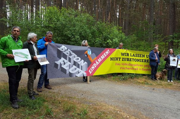 BN-Aktive protestieren vor Ort gegen das geplante Gewerbegebiet, unter anderem BN-Regionalreferent Reinhard Scheuerlein und BN-Vorsitzender Richard Mergner (beide links im Bild).