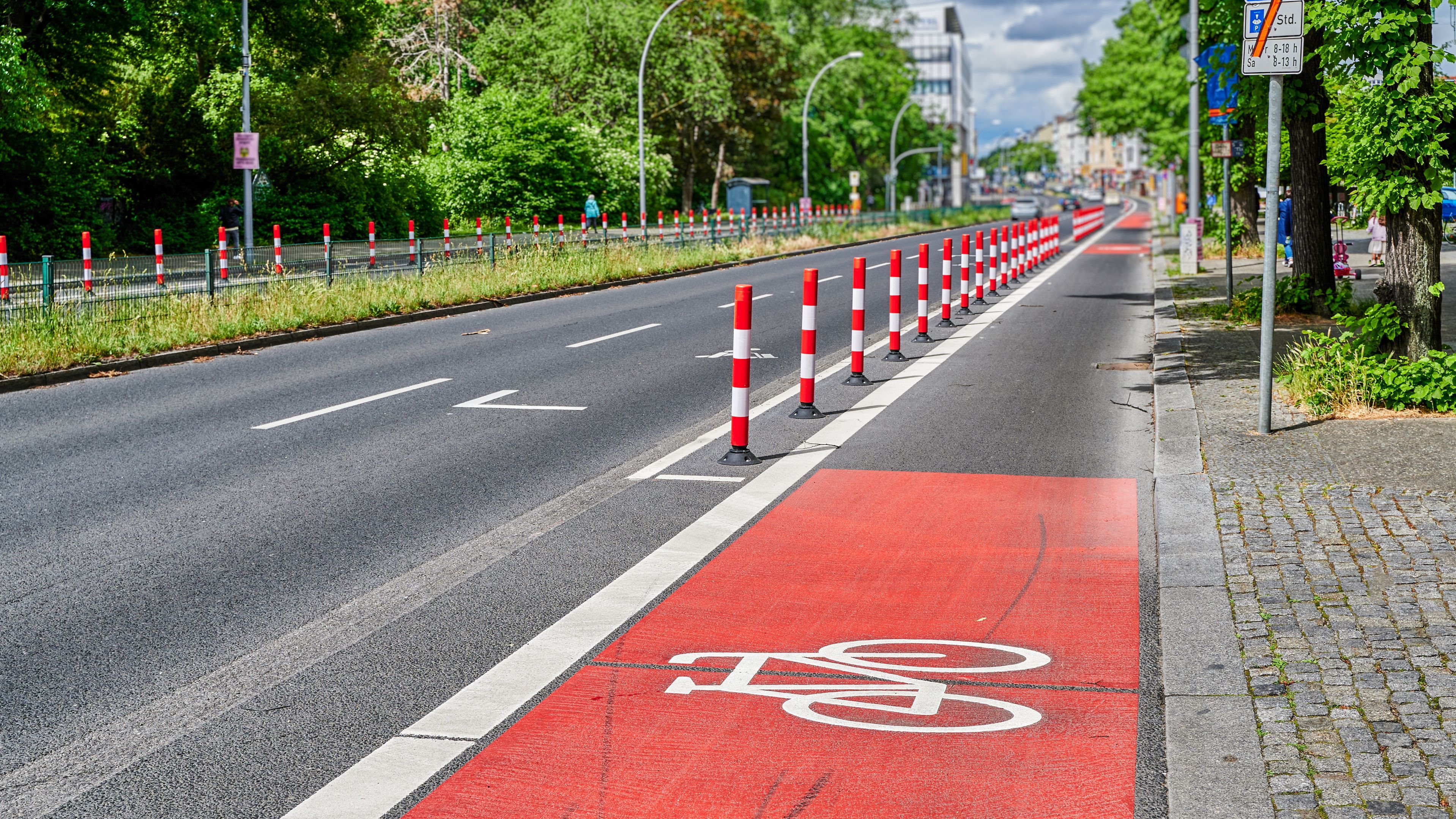 Je mehr Verkehr und je höher die Geschwindigkeit, desto stärker sollte der Radverkehr vom Kfz-Verkehr getrennt werden. Ausreichende Breiten und Sicherheitstrennstreifen sind dabei entscheidend. (Foto: Mickis Fotowelt/stock.adobe.com) Radverkehr und Radwegebau: Durch Poller getrennter Radweg neben einer Straße in der Stadt