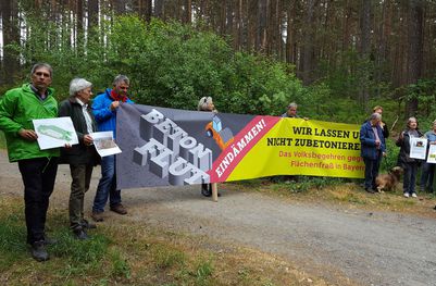 BN-Aktive protestieren vor Ort gegen das geplante Gewerbegebiet, unter anderem BN-Regionalreferent Reinhard Scheuerlein und BN-Vorsitzender Richard Mergner (beide links im Bild).
